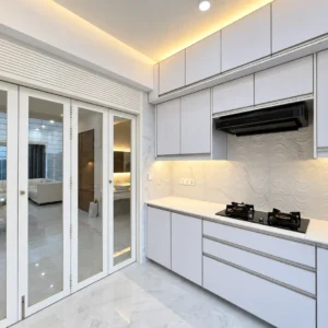 Pale kitchen cabinets, textured backsplash, warm lighting, and glazed doors in an edited AG Bashundhara portfolio image.